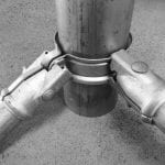 A vertical metal pipe held in universal post clamps
